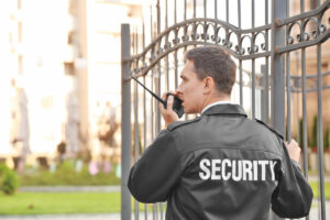 Male security guard with portable radio, outdoors